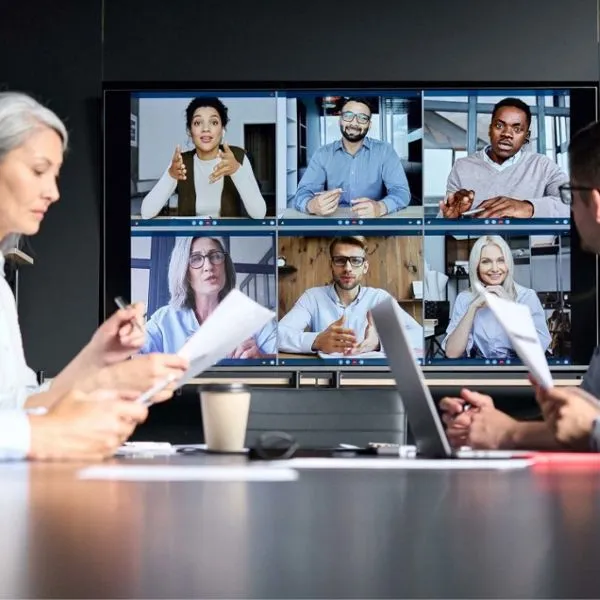 Ein Bildschirm im Besprechungsraum mit einer Videokonferenz mit acht Personen